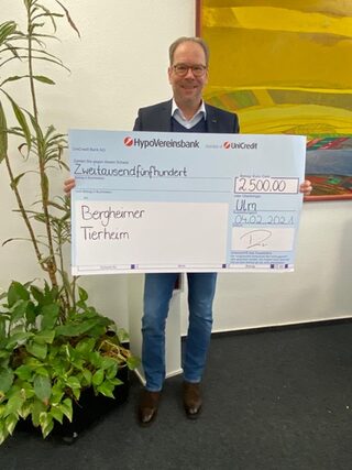 Bürgermeister Volker Mießeler hält einen großen Scheck über 2500 Euro für das Bergheimer Tierheim in der Hand